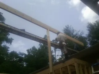 Carpenter setting a ridge beam over a new addition frame — Ice Dam Removal by Roofing Brothers in Red Cloud