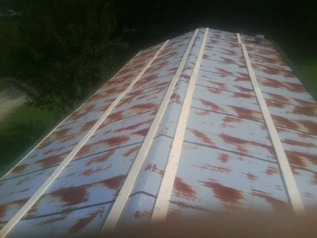 Rusted metal roof panels with new wood purlins before replacement — Storm Damage Roof Repair in Red Cloud by Roofing Brothers